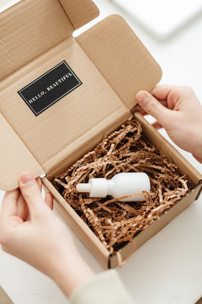 Close-up of hands unboxing a skincare serum in sustainable packaging with elegant design.